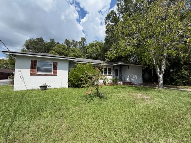Single-story painted brick home with a front lawn in Northeast Florida